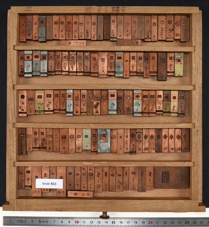 Tiroir de matrices : chiffres et lettres encadrés sur divers corps
